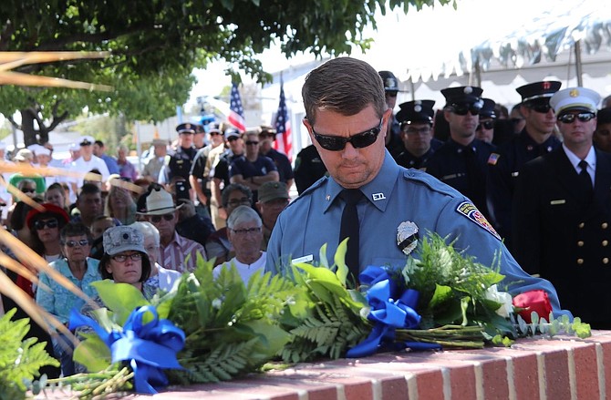 City of Fallon employee and volunteer fireman Gary Johnson places a rose at the on the city’s 9/11 Memorial in 2019.