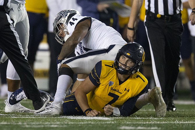 California quarterback Chase Garbers looks up after being sacked by Nevada defensive end Daniel Grzesiak on Sept. 4, 2021, in Berkeley, Calif. (AP Photo/D. Ross Cameron)