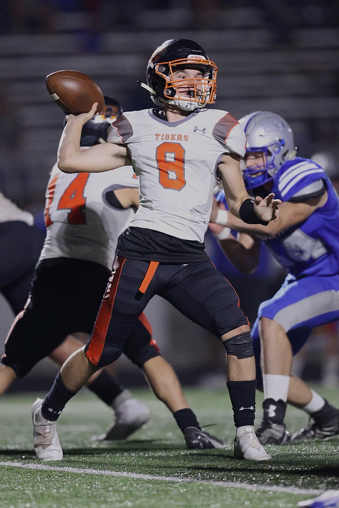 Sophomore quarterback Owen Evans winds up to throw a pass against McQueen last Friday. Douglas football is hoping to get its first home game of the season in Friday night against Reno.