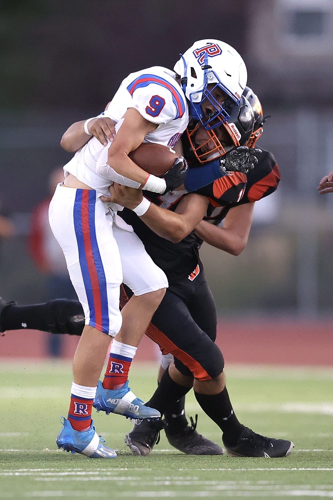 Douglas High linebacker Gabe Foster wraps up a Reno ballcarrier last Friday during the Tigers’ home opener.