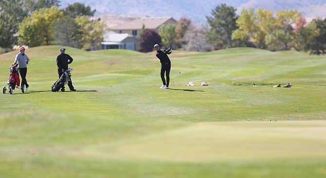 A golfer hits an approach shot onto the green during the 2019 Dayton Valley Golf Club Q-School Qualifier.