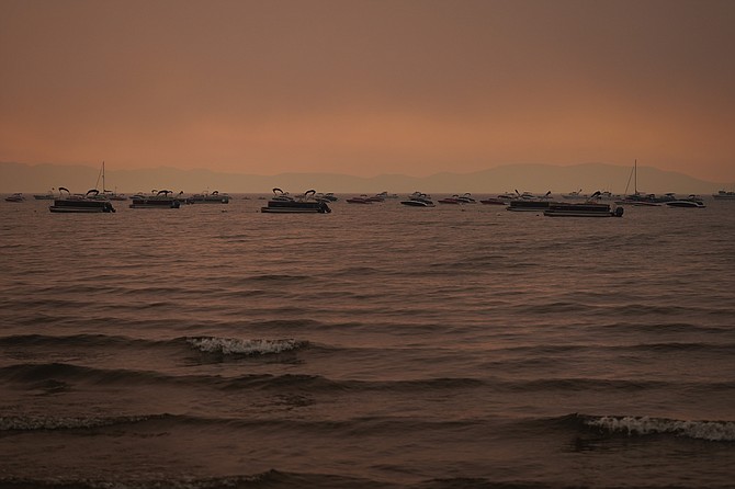 Boats float in the water away from a dock in South Lake Tahoe, Calif., as the Caldor Fire approaches on Aug. 31, 2021. (AP Photo/Jae C. Hong,File)