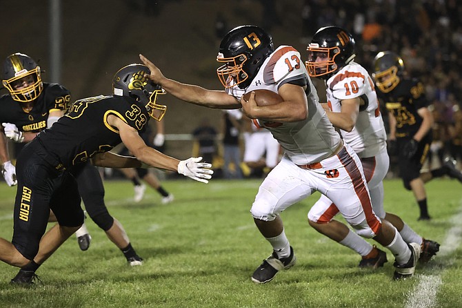 Douglas High running back Gabe Foster (13) stiff arms a Galena defender Friday evening. Foster ended the night with 226 rushing yards and four touchdowns.