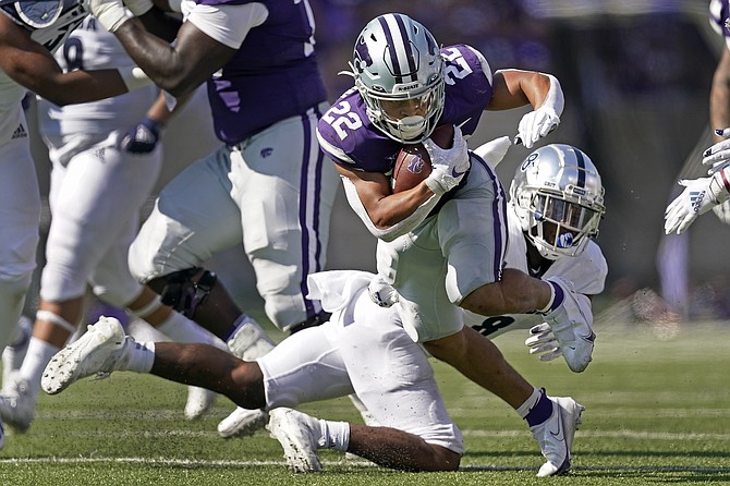 Kansas State running back Deuce Vaughn (22) gets past Nevada defensive back JoJuan Claiborne on a run during the second half of an NCAA college football game Saturday, Sept. 18, 2021, in Manhattan, Kan. (AP Photo/Charlie Riedel)