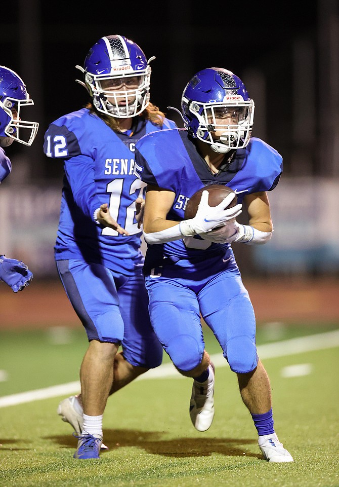 Carson High Running Back Jacob Campbell takes the hand off from quarterback Vinny Ferretti, during the Senators' homecoming game against McQueen Friday night. Campbell rushed for 126 yards on 19 carries in the Senators' loss.