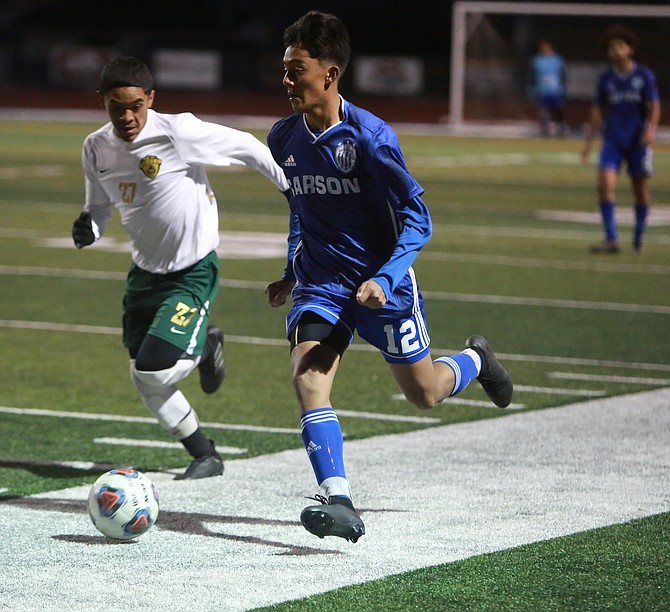 Josue Rivas (12) dribbles up the near sideline against Hug Wednesday night. Rivas had an assist in the Senators' 3-2 loss to undefeated Hug.