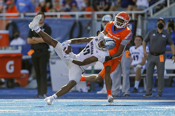 Nevada wide receiver Justin Lockhart makes a catch in front of Boise State cornerback Markel Reed on Oct. 2, 2021, in Boise, Idaho. (AP Photo/Steve Conner)