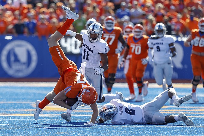 Boise State tight end Kurt Rafdal (87) is knocked off his feet by Nevada defensive back JoJuan Claiborne after a reception Oct. 2, 2021, in Boise, Idaho. (AP Photo/Steve Conner)