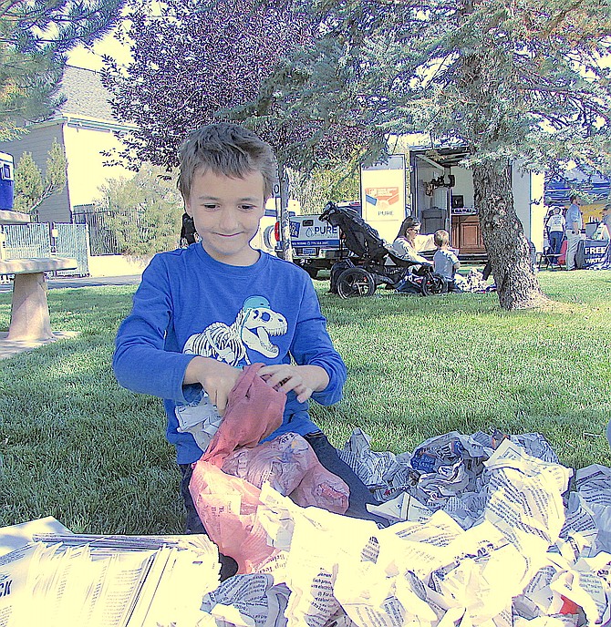 Seven-year-old Carson City resident Logan Barrett stuffs “Guts,” the scarecrow during the Fall Festival in Gardnerville on Saturday. "Guts" is on display at The Record-Courier.