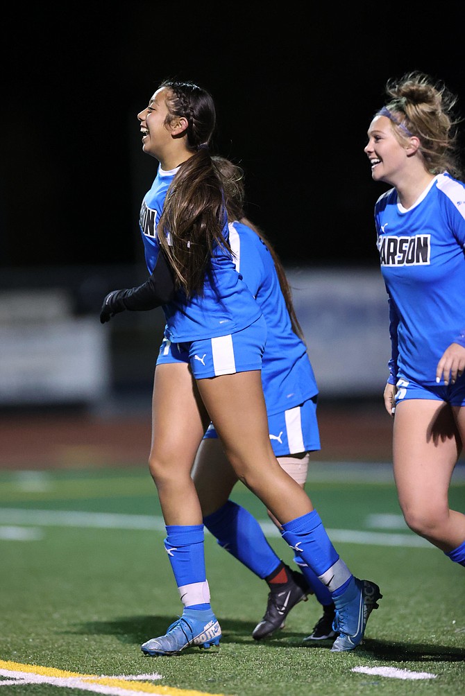 Monserrat Iza (21) smiles amongst her teammates after scoring in the final moments of a 2-2 tie against Damonte Ranch Tuesday night on Senior Night.