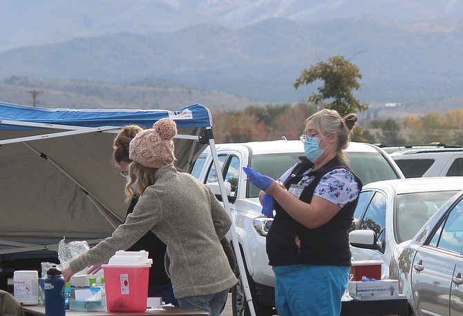 Residents lined up for a drive-through flu shot at the Douglas County Community and Senior Center on Wednesday. A drive-through combined flu and coronavirus vaccination clinic is 9 a.m. to 1 p.m. Saturday at Douglas High School.