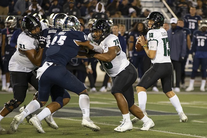 Hawaii quarterback Brayden Schager (13) drops back to pass against Nevada in the second half in Reno on Oct. 16, 2021. (AP Photo/Tom R. Smedes)