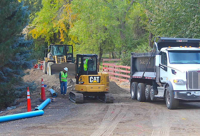 Workers trench along Genoa Street on Wednesday morning to install a pipeline.