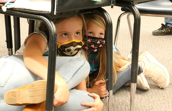 Bordewich Bray Elementary School third graders Alice Williams, left, and Zoey Craig take part in the school’s Great Nevada ShakeOut drill Oct. 21, 2021. (Photo: Jessica Garcia/Nevada Appeal)