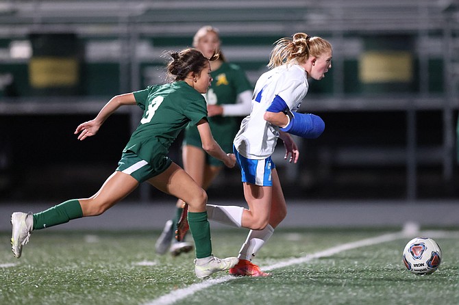Carson midfielder Gracie Walt dribbles away from Bishop Manogue forward Ella Hallert during the game between the Bishop Manogue Miners and the Carson High Senators.
