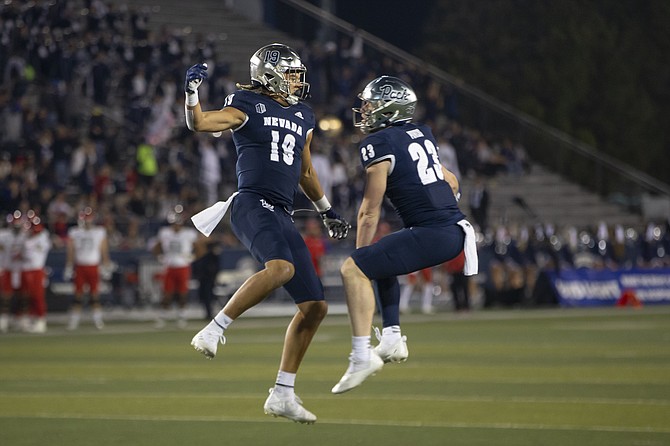 Nevada's Cole Turner (19) and Jacques Badolato-Birdsell (23) celebrate after a touchdown against UNLV during the first half of an NCAA college football game in Reno, Nev., Friday, Oct. 29, 2021.