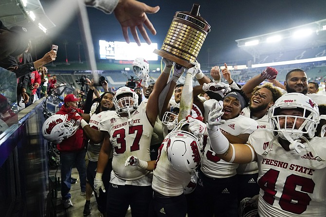 Fresno State players hoist the Old Oil Can trophy while celebrating the team's 30-20 win against San Diego State on Oct. 30, 2021, in Carson, Calif. (AP Photo/Jae C. Hong)