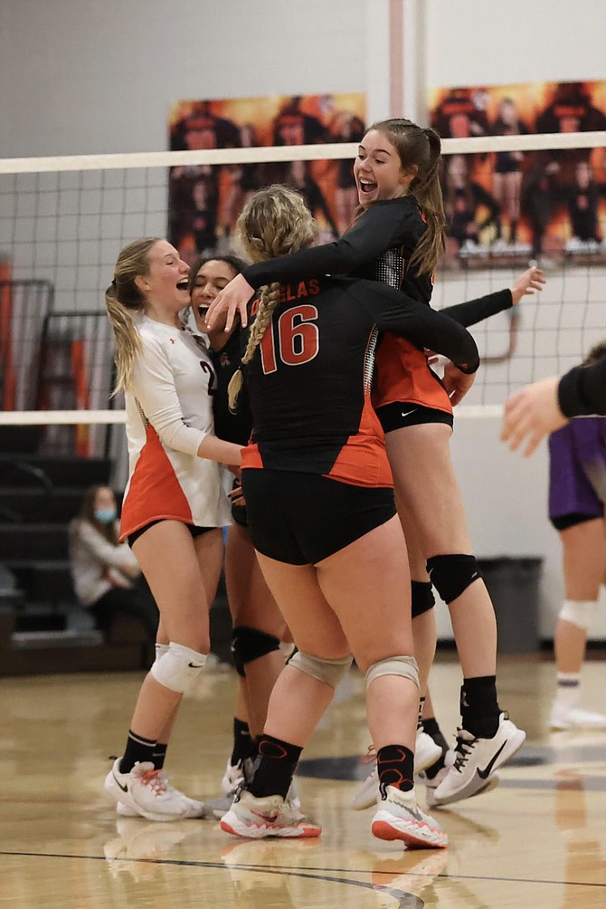 Addy Doerr (4) jumps into the arms of Riley Mello (16) alongside Sumer Williams (2) and the rest of the Tigers after Douglas took down Spanish Springs in five sets Monday night in the Class 5A regional quarterfinal.