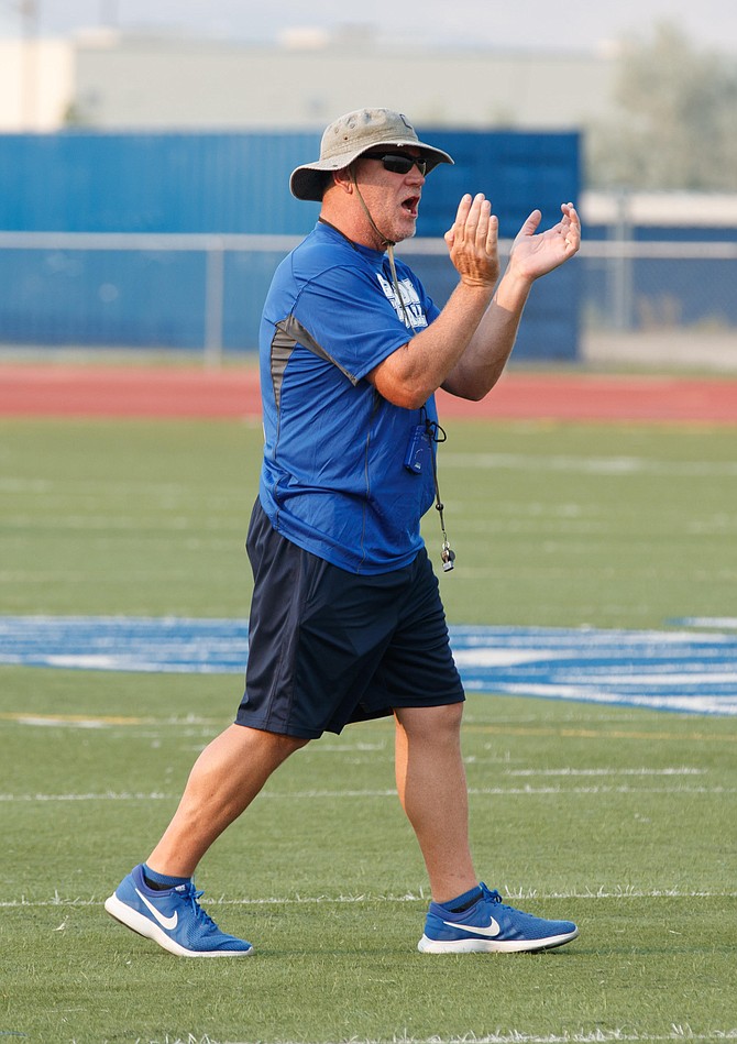 Longtime Carson High football coach Blair Roman claps during a Senator football practice. Roman announced Wednesday afternoon he is stepping down from his duties as the Senators' head coach.