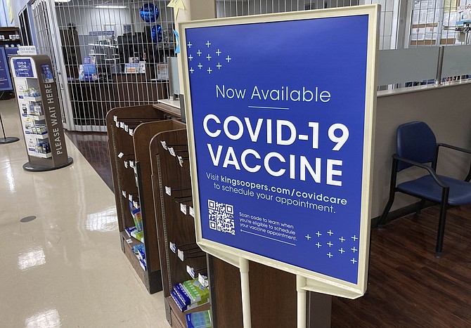 A sign notifies customers that COVID-19 vaccinations are available at a pharmacy in a grocery store in Monument, Colo., on Oct. 23, 2021. (AP Photo/David Zalubowski)