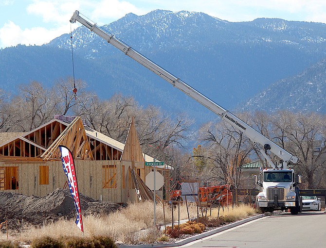 Workers lower trusses in place at a home under construction in Minden on Thursday morning.