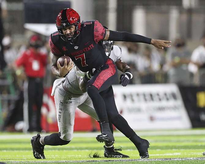 San Diego State quarterback Lucas Johnson tries to get away from Hawaii defensive back Solo Turner on Nov. 6, 2021, in Honolulu. (AP Photo/Marco Garcia)