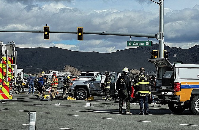 Carson City firefighters extinguish a fire in a silver pickup at a fatal collision in southern Carson City. Tara Addeo photo