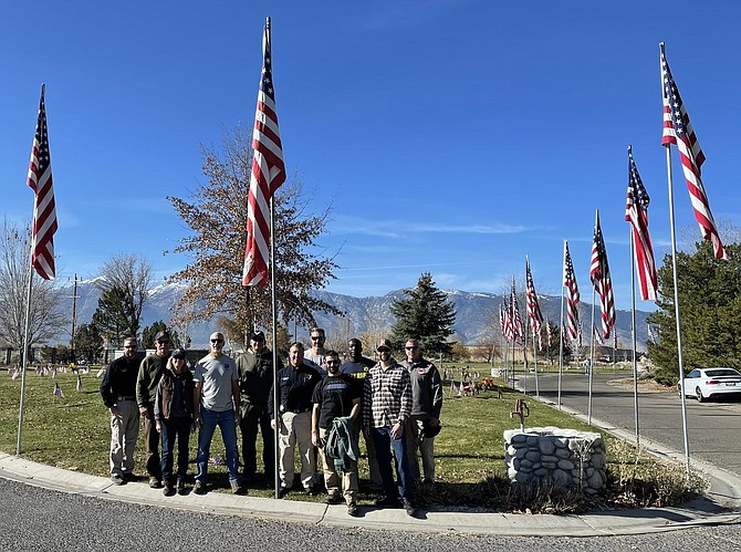 Members of the Douglas County Sheriff's Office honor guard and the mounted posse helped put up U.S. flags at Eastside Memorial Park in Minden on Monday in preparation for Veterans Day on Thursday.