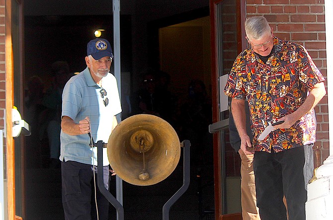 Retired U.S. Air Force Staff Sgt. Guy Proto rings the bell as Dennis Little stands at the entrance of the Carson Valley Museum & Cultural Center.