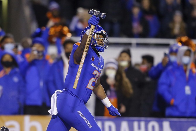 Boise State running back Andrew Van Buren leads the team on to the field carrying the Dan Paul Hammer before the Nov. 20, 2021 game against New Mexico in Boise, Idaho. (AP Photo/Steve Conner)