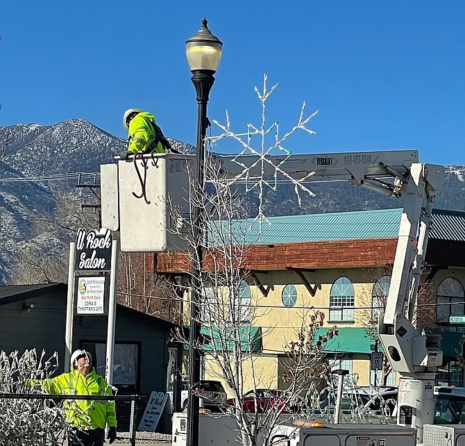 R-C Associate Publisher Tara Addeo caught Gardnerville workers hanging up the street-lamp snowflakes on Monday.