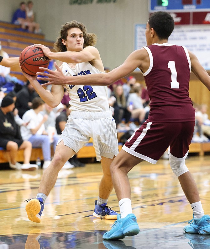 Parker Story dishes out one of his several assists in the opening half of Carson High boys basketball's first regular season game Saturday against Dayton.
