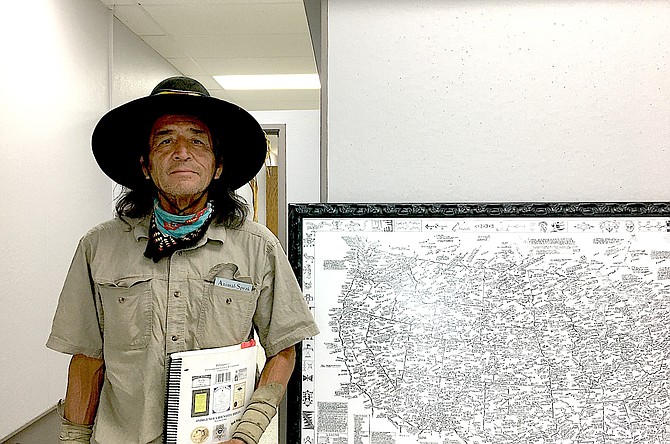 Dahlahk Pahtahlngee stands in front of a map of Indian Tribes he gave The Record-Courier.