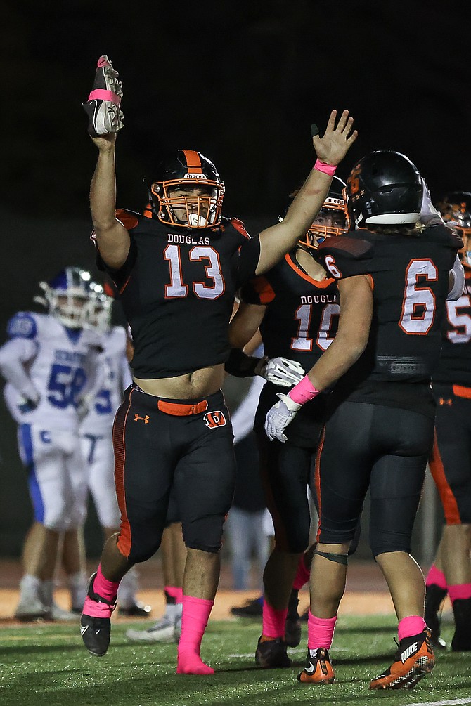 Douglas High’s Gabe Foster (13) puts his hands up in celebration after scoring a touchdown against Carson High this fall. Foster earned a first team all-region selection at linebacker and second team nod at running back along with several other Tiger players.