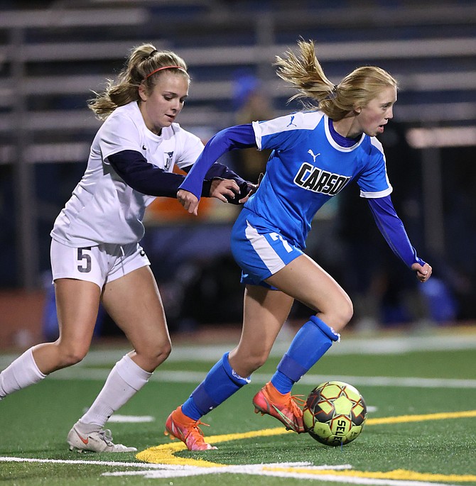 Carson High midfielder Gracie Walt dribbles past a Damonte Ranch defender during an October contest between the two programs. Walt was named a first team all-region midfielder for her play this season.