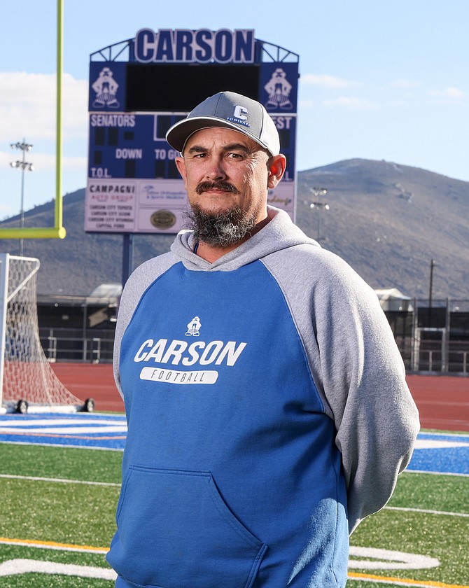 Carson High's newest football coach, Ryan Boshard, poses for a photo on the turf field at the high school Friday.
