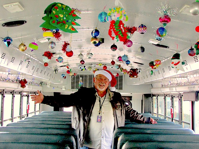 Roy Aarons stands in the school bus decorated with ornaments made by students on Monday. Schools in Douglas County close for winter break on Dec. 17. Aarons is retiring at the end of the year after a decade.