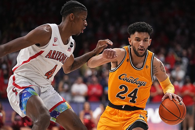 Wyoming guard Hunter Maldonado fends off Arizona’s Dalen Terry on Dec. 8, 2021, in Tucson, Ariz. (AP Photo/Rick Scuteri)