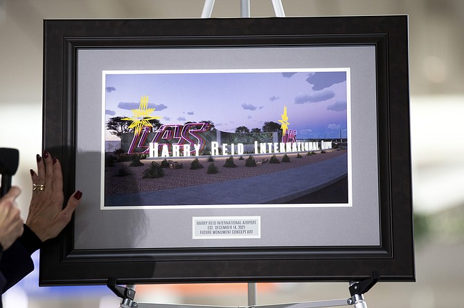 Clark County Director of Aviation Rosemary Vassiliades presents a framed illustration of proposed airport signage during the official renaming of McCarran International Airport to Harry Reid International Airport at the airport in Las Vegas on Dec. 14, 2021. (Steve Marcus/Las Vegas Sun via AP)