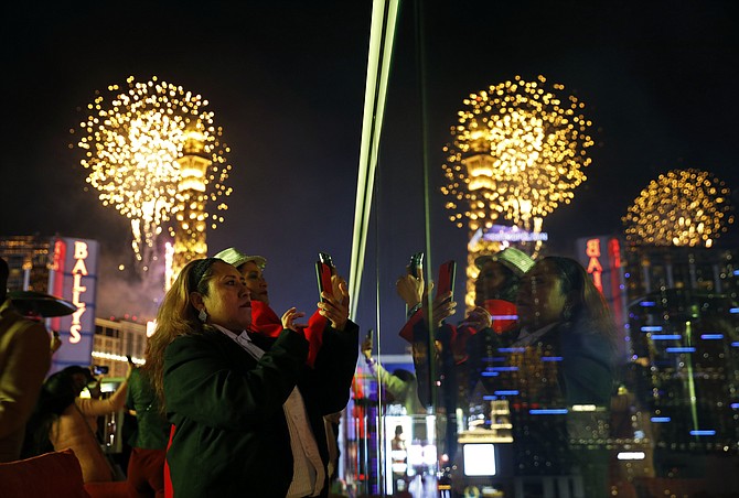 Revelers watch at Drai's nightclub as fireworks explode on the Las Vegas Strip during a New Year's celebration on Jan. 1, 2019, in Las Vegas. (AP Photo/John Locher, File)