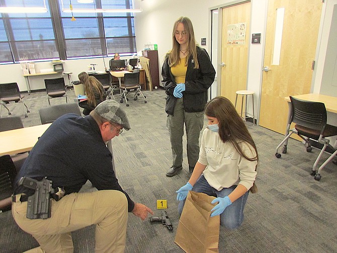 Douglas County Sheriff’s Investigator Steve Schultz shows students how to properly handle evidence.