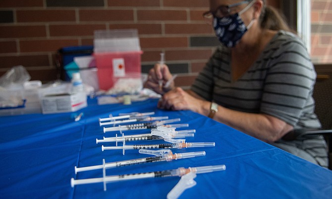 COVID-19 vaccines are loaded into syringes during a POD inside the Joe Crowley Student Union on Aug. 13 2021.