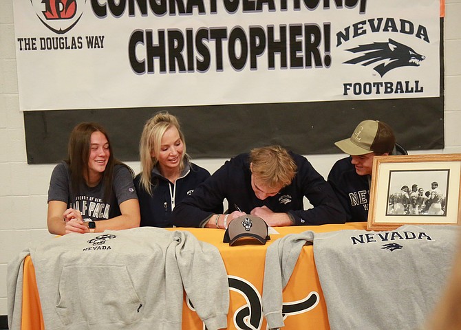 Douglas High senior Chris Smalley signs his National Letter of Intent to play football next fall at the University of Nevada Reno. Pictured alongside Chris from left to right are his sister, Madi, mother, Wendy, and brother, Cole.