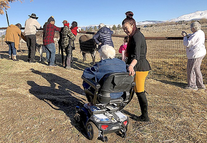 A Carson Valley Senior Living resident rides a scooter on Sunday to visit with retired racehorses. Photo Special to The R-C