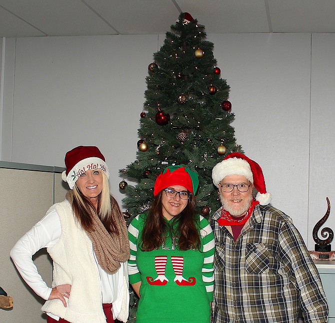 R-C Publisher Tara Addeo, Staff Writer Sarah Drinkwine and Editor Kurt Hildebrand stand in front of the tree Foothill resident Margaret Pross donated to The Record-Courier.