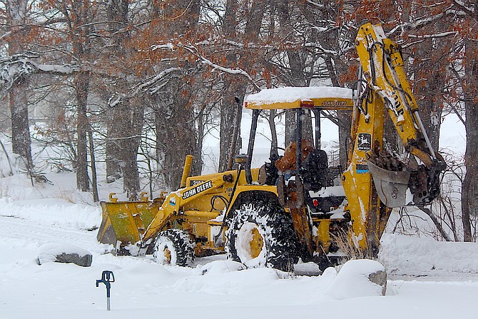 A Carson Valley resident clears snowy roads in a back hoe on Tuesday.
