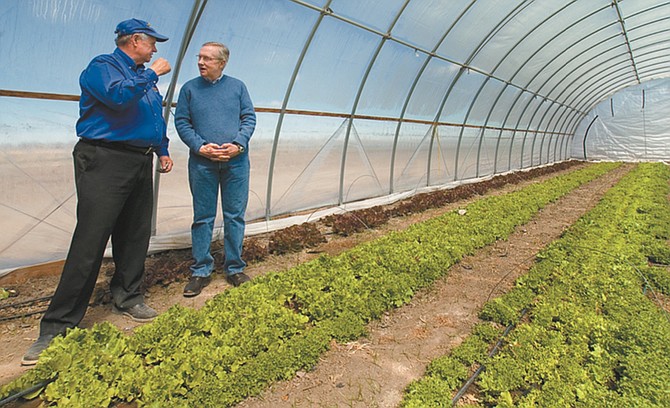 Rick Lattin, left, of Lattin Farms explains how the hoop greenhouse works to Nevada Sen. Harry Reid in 2010. (Photo: Kim Lamb/LVN)