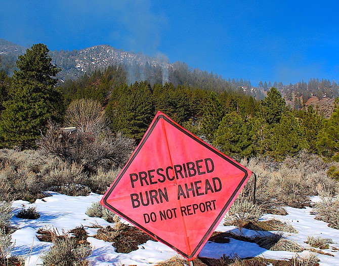 A sign asks residents not to report a prescribed burn off Centennial north of Genoa on Thursday morning.