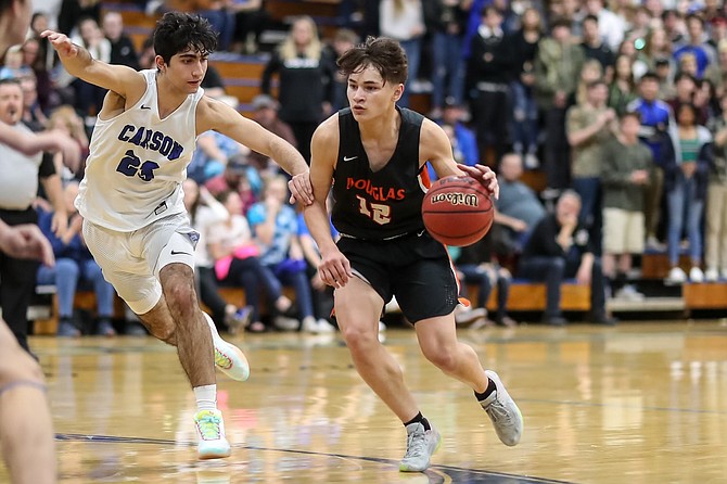Carson High's Parsa Hadjighasemi guards Douglas' Dakota Jones during a game in February of 2020. With the Carson City School District canceling school for Thursday and Friday, both Carson and Douglas basketball games have been postponed.
