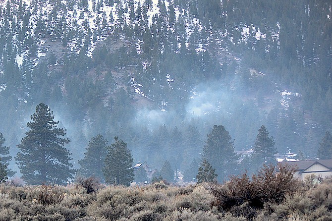 Smoke rises above Genoa on Jan. 5 as the U.S. Forest Service conducts pile burning.